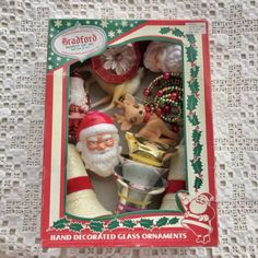 a boxed christmas ornament with santa claus and other ornaments