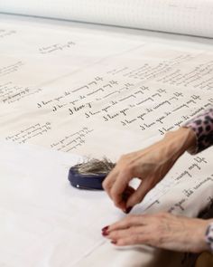 an older woman is writing on a sheet of paper