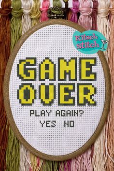 a cross - stitch pattern with the words game over on it and some tassels