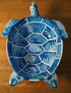 a blue and white ceramic turtle dish on a wooden table