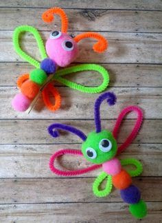 two colorful bugs made out of yarn sitting on top of a wooden floor next to each other