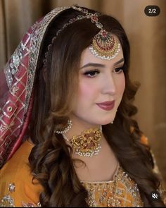 a woman wearing a bridal outfit and jewelry