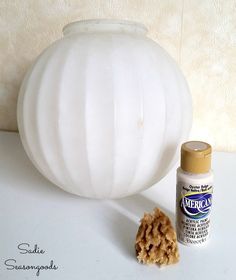 a white vase sitting on top of a table next to a brown and white object