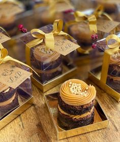 several small boxes filled with cupcakes on top of a wooden table