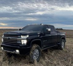 a black truck is parked in a field