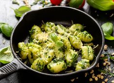 broccoli and pesto ravioli in a skillet on a black surface