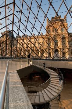 the inside of a glass building with a spiral stair case in it's center