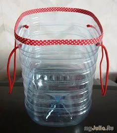 a clear plastic container with red ribbon around the top and bottom, sitting on a black table