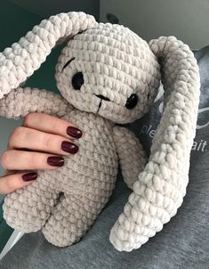 a person holding a stuffed animal in their hand with nails on it's fingers