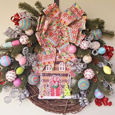 a wreath decorated with gingerbread houses, candy canes and candies is hanging on the wall