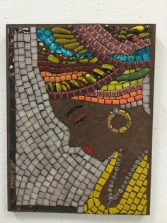 an art piece made out of glass and mosaic tiles with a woman's face on it