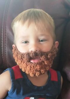 a little boy with a beard sitting in a chair