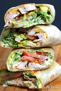 three burritos stacked on top of each other with lettuce and tomatoes