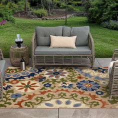 an outdoor area with furniture and flowers on the rug