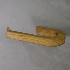 a wooden handle on the wall for a towel or toilet paper dispenser