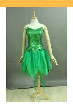 a green dress with sequins on the bottom and straps is sitting on a mannequin