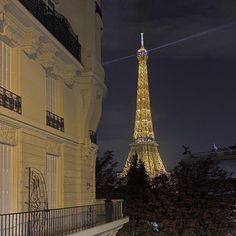 the eiffel tower lit up at night in paris, france as seen from an apartment balcony