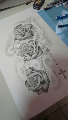 a cross and three roses on a sheet of paper