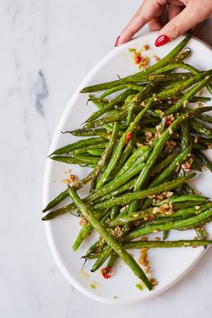 a white plate topped with green beans covered in seasoning