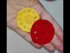 two crocheted pieces are sitting on someone's hand, one is yellow and the other is red