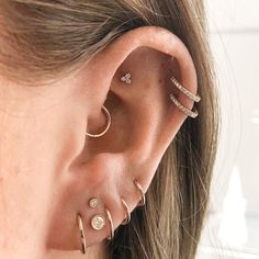 a woman's ear with three different piercings