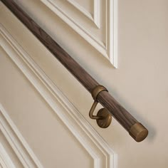 a door handle on the side of a white door with a wooden handle and brass fittings