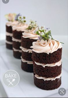 three chocolate cakes with white frosting and flowers on each one slice are sitting on a plate