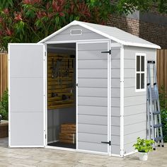 a white shed sitting on top of a patio