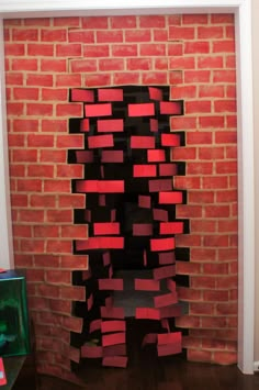 a red brick wall that has been made into a sculpture with black and red squares on it