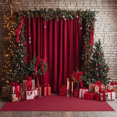 christmas decorations and presents in front of a brick wall with red drapes on it