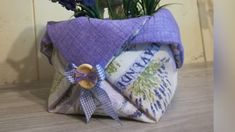 a purple bag sitting on top of a wooden floor next to a potted plant