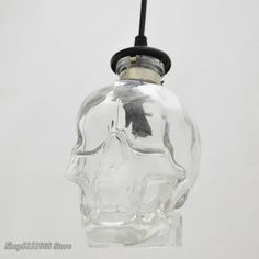 a clear glass skull hanging from a black cord