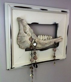 an animal skull mounted to the side of a wall with beads hanging from it's sides