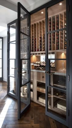 an open wine cellar with glass doors leading into the kitchen and dining room area is shown