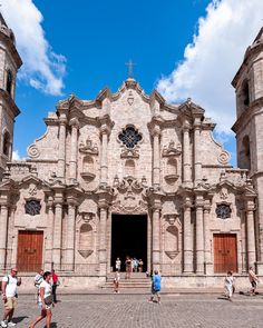 people are walking around in front of an old church