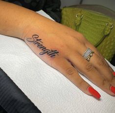 a woman's hand with the word strength tattooed on it