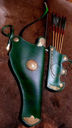 a green leather bag with some arrows and other items