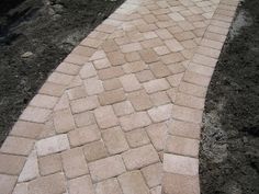 a brick walkway in the middle of some dirt