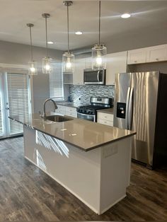 a kitchen with stainless steel appliances and white cabinets