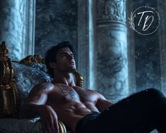 a shirtless man sitting on top of a couch in front of pillars and columns