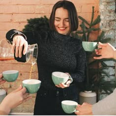 a group of people holding cups and pouring something into them