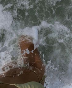 a woman laying on top of a surfboard in the ocean next to a wave