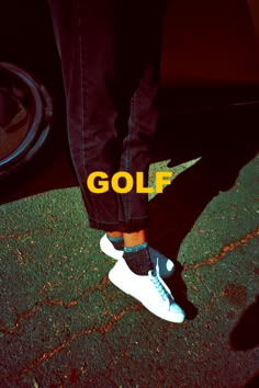 a person standing in front of a car with the word golf written on their feet