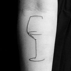 a black and white photo of a person's arm with a wine glass tattoo on it