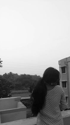 a woman standing on top of a roof next to a tall building