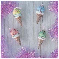 three ice cream cones with sprinkles on them sitting next to purple tinsel