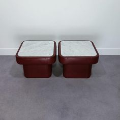 pair of red leather ottomans with marble top