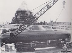 an airplane is being worked on in the process of being lifted by a crane and surrounded by other vehicles