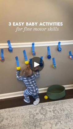 a baby standing in front of a wall with blue tape on it's sides