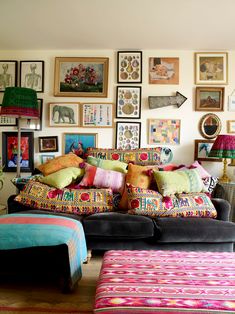 a living room filled with lots of colorful furniture and pictures on the wall above it